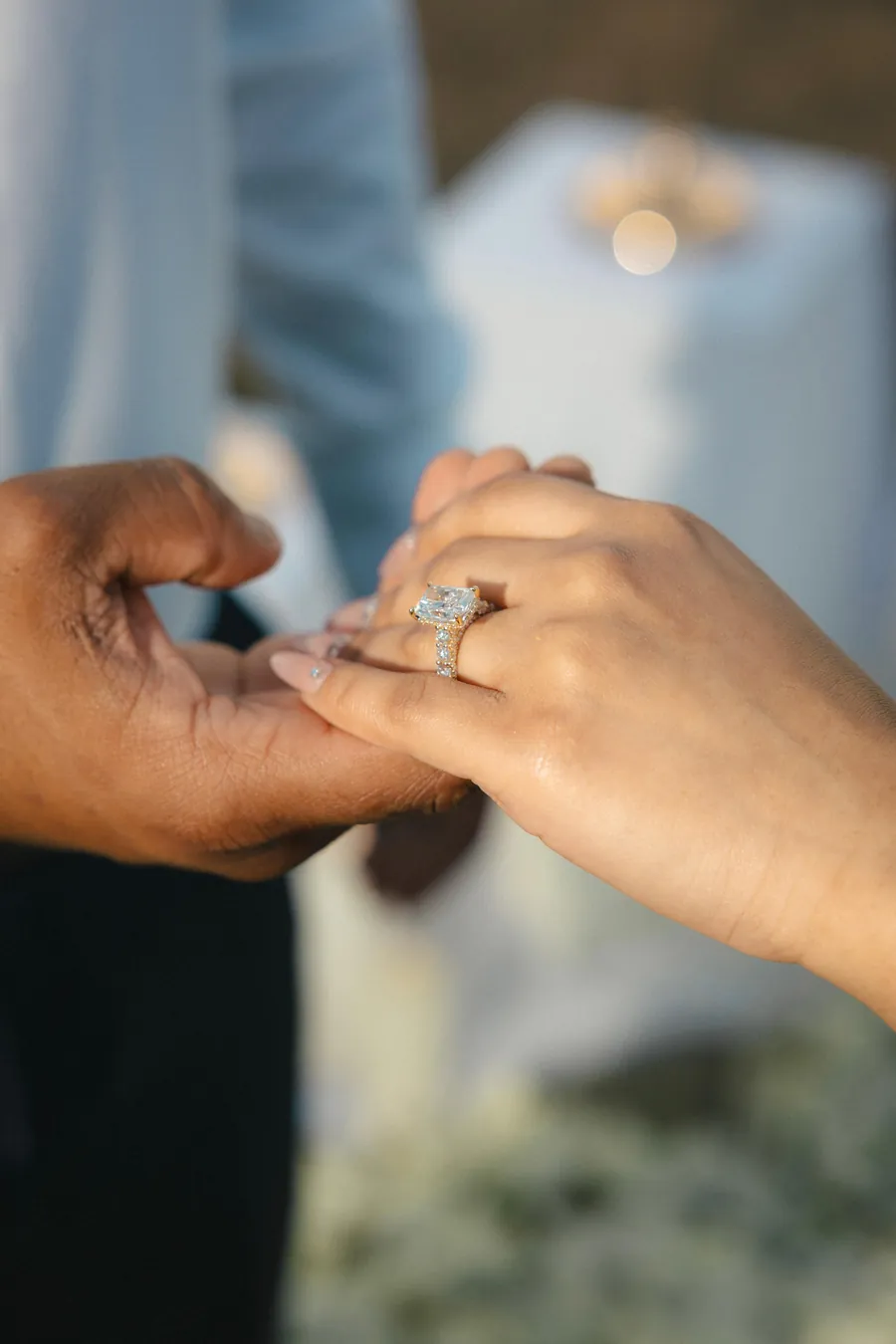 Jaz holding Rianna's hand, the engagement ring on her finger